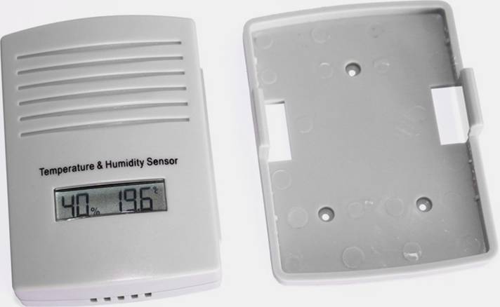 Capteur de température et d'humidité avec affichage LCD. Affiche 40% d'humidité et 19,6°C. Couvercle du boîtier retiré, ouvert à côté.