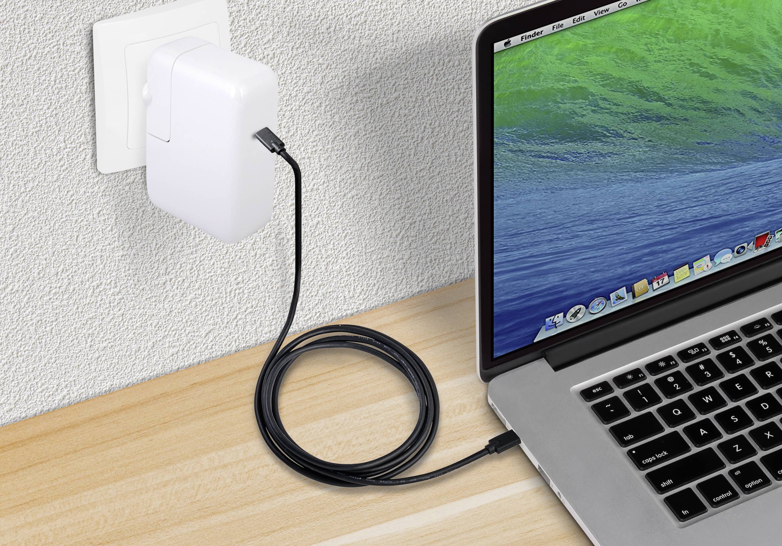 Un ordinateur portable est connecté à une prise électrique via un long câble USB pour charger sa batterie.