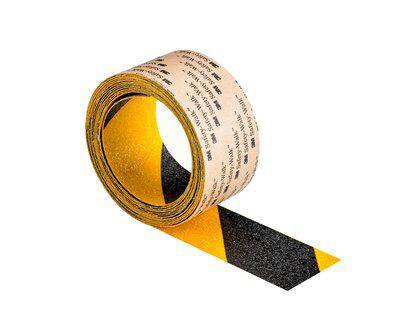 Une bande antidérapante jaune et noire est partiellement déroulée. La bande offre de la sécurité sur des surfaces glissantes.