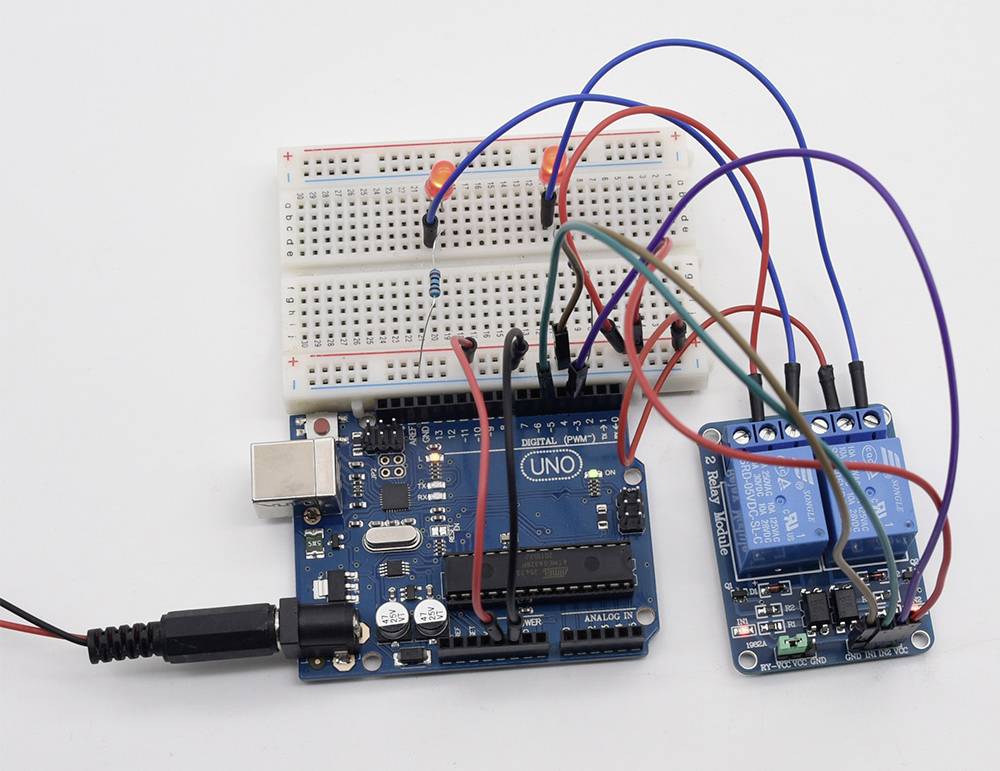 Kit Arduino avec breadboard, câblage et module de relais. Le breadboard est connecté à des LED et à une résistance, tous les composants sont câblés électriquement.