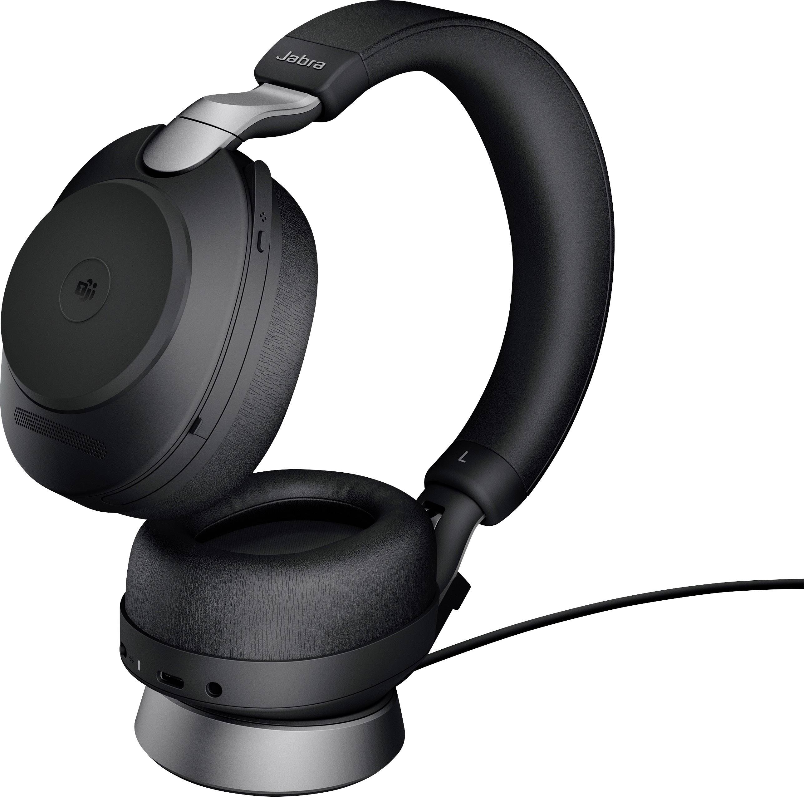 Écouteurs noirs sans fil, de type over-ear, posés sur un chargeur. Ils ont un design moderne et ergonomique, adaptés pour écouter de la musique ou passer des appels.