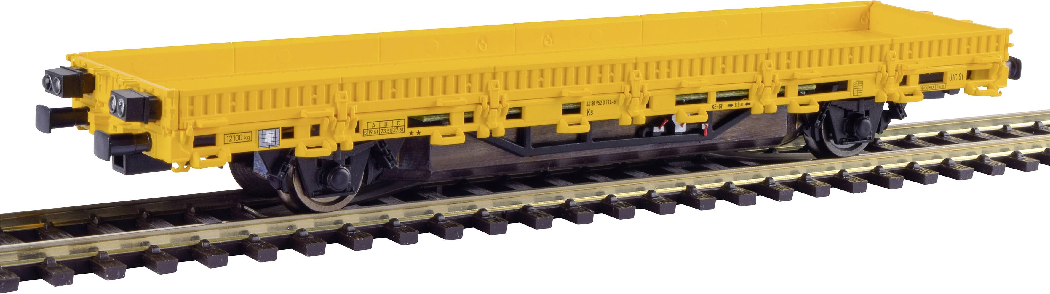 Wagon de marchandises jaune sur des rails, sans chargement. Le wagon est dépourvu de parois latérales, idéal pour le transport de marchandises encombrantes.