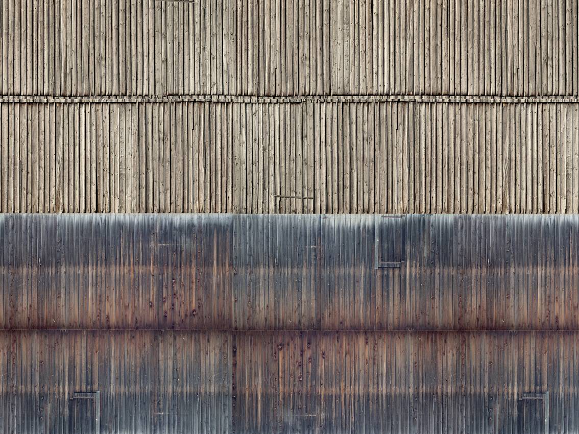 Motif structurel vertical en bois dans deux nuances de couleur différentes : des rayures claires en haut, des teintes plus foncées avec des nuances rougeâtres et bleues en bas.