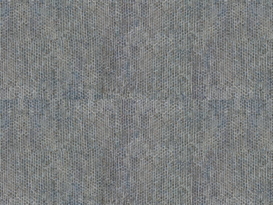 Gros plan sur une surface structurée composée de pierres gris-bleu formant un motif uniforme de petits pavés rectangulaires.