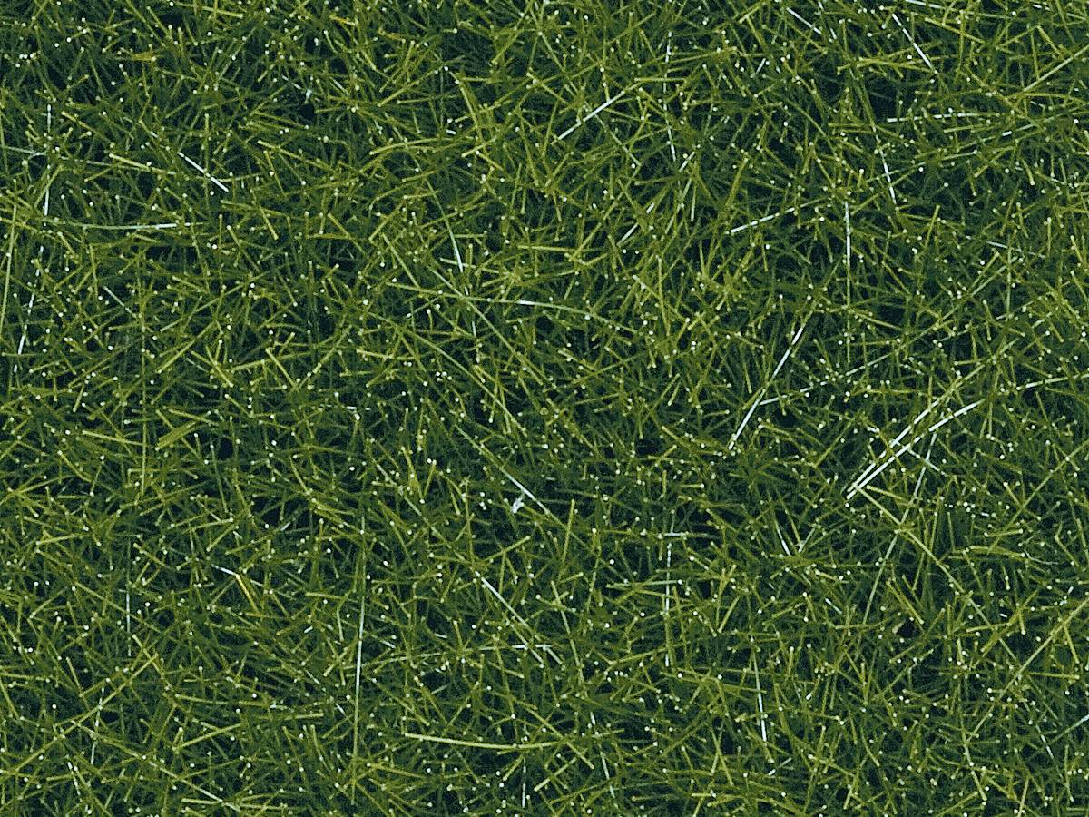 Gros plan sur un gazon synthétique vert, dense, avec une texture fine et un reflet humide qui imite une surface d'herbe naturelle.