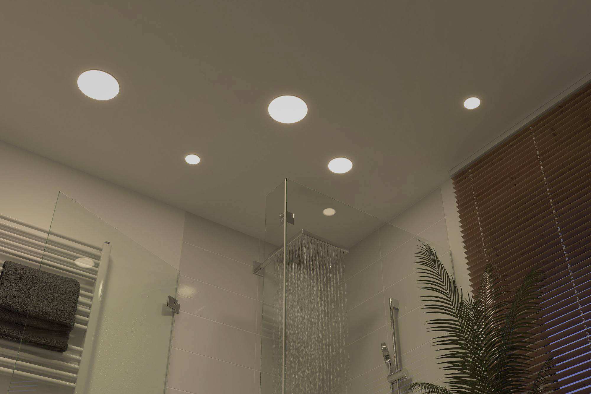 Dans une salle de bain moderne, plusieurs spots encastrés au plafond éclairent la pièce d'une lumière chaleureuse.