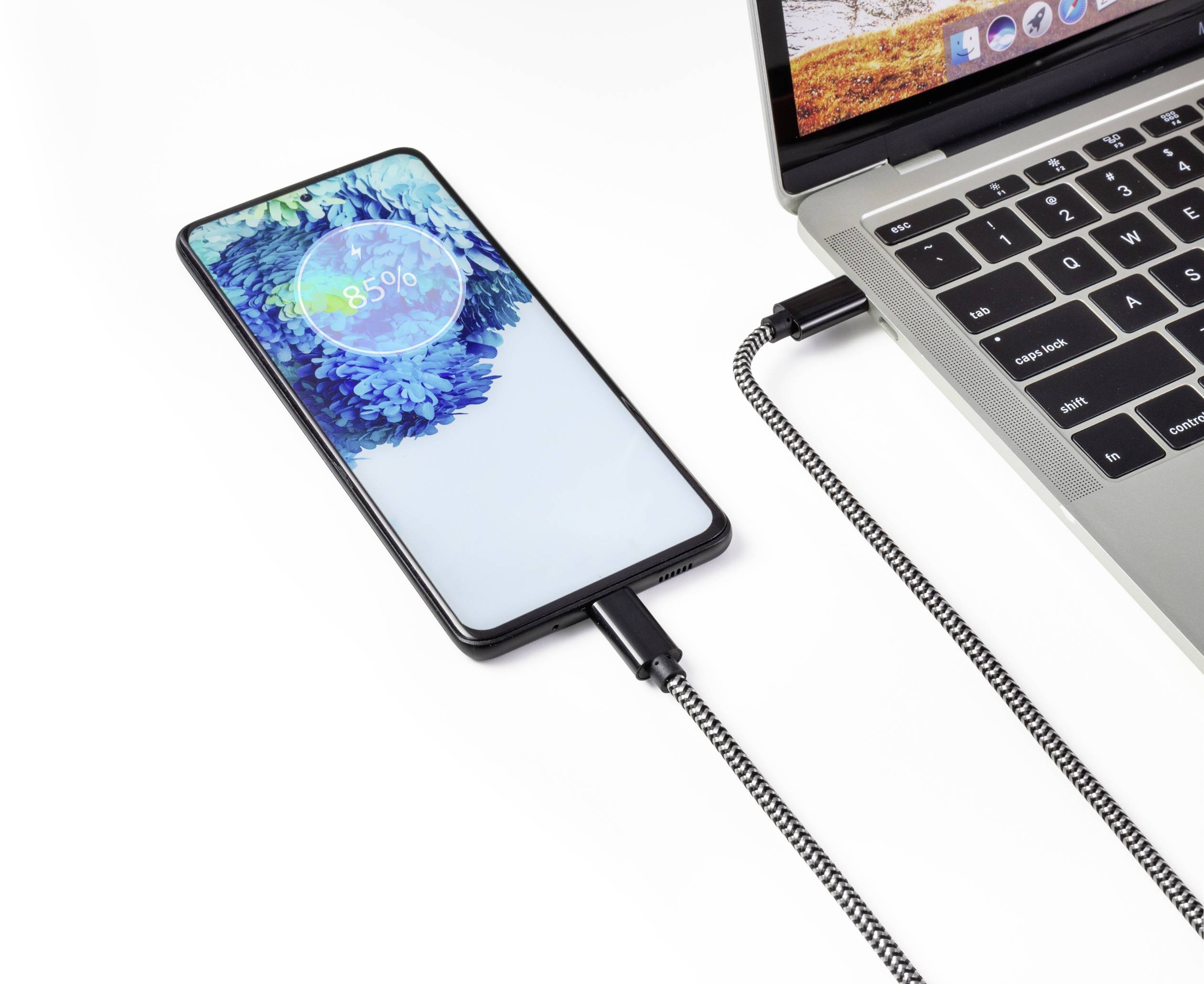 Un smartphone est en train de se charger via un câble USB sur un ordinateur portable. L'écran affiche un niveau de batterie de 85%.