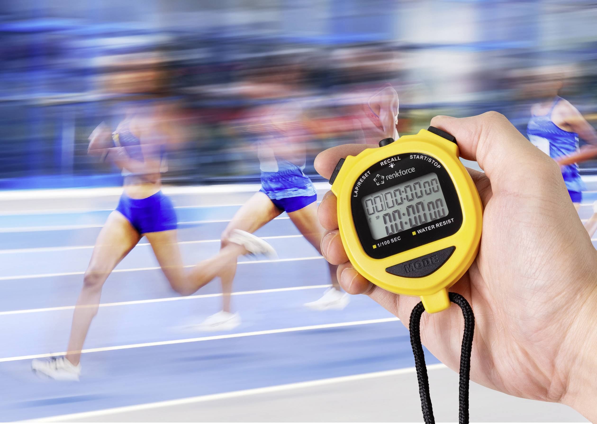 Une main tient un chronomètre jaune au premier plan, tandis que des coureurs flous en tenue de sport bleue sprintent en arrière-plan sur une piste d'athlétisme.