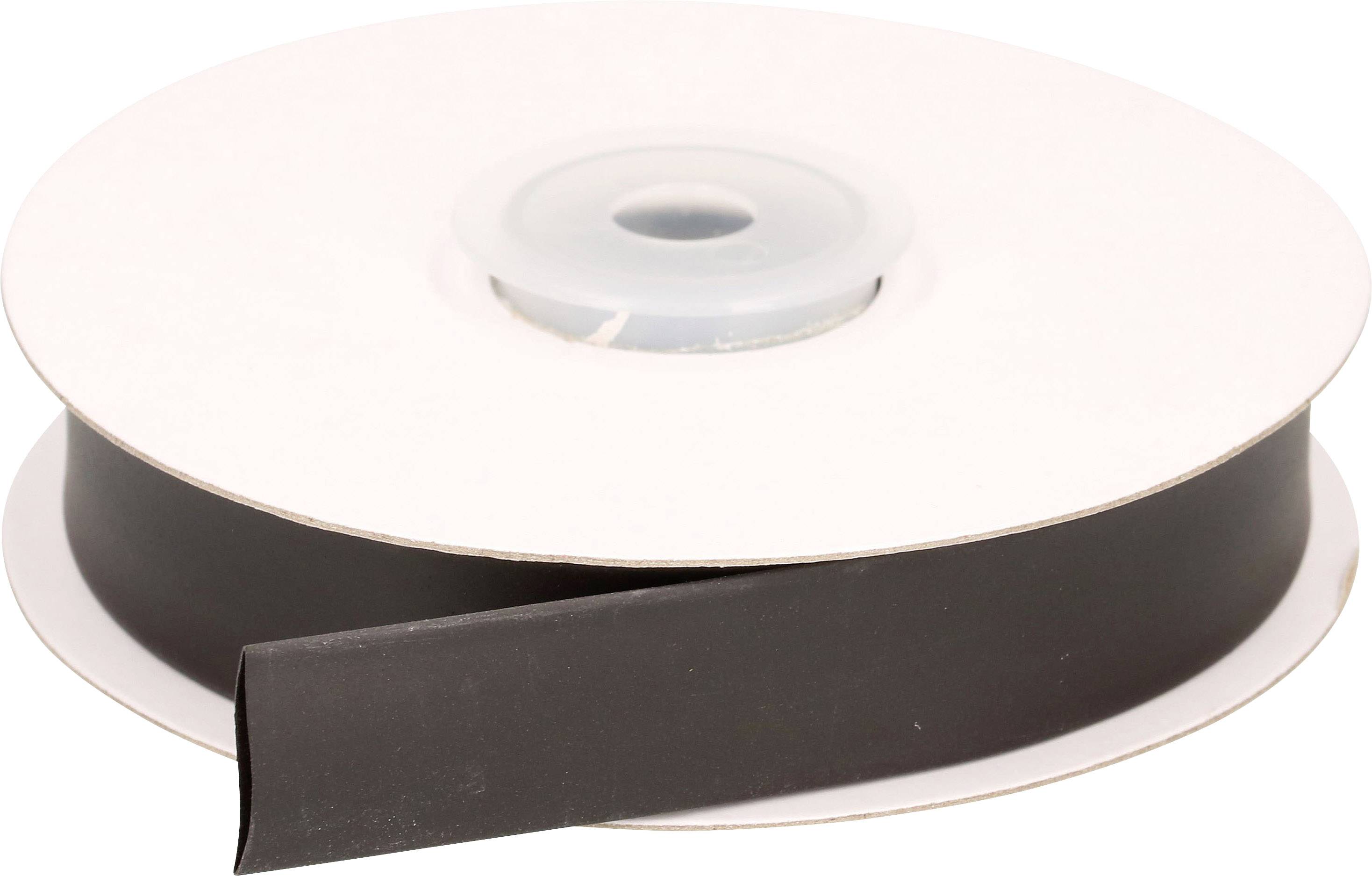 Une bobine de bande magnétique noire, partiellement déroulée, est posée sur une table.