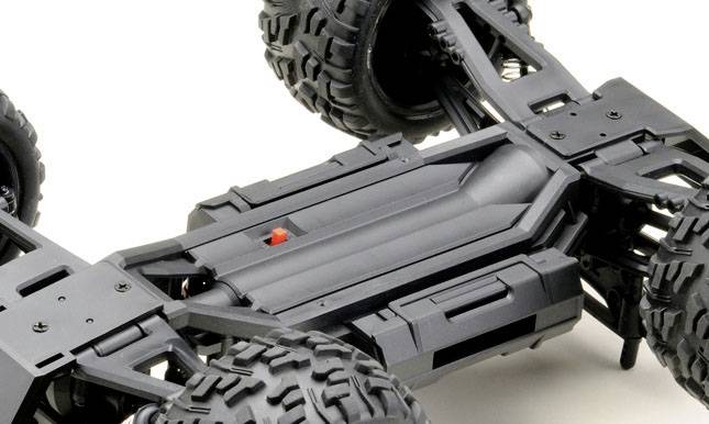 L'image montre le châssis d'une voiture télécommandée avec de grandes roues tout-terrain et un cadre robuste en plastique noir.