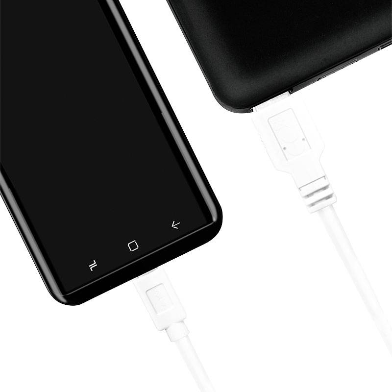 Smartphone connecté à un câble USB. L'appareil est en cours de charge.