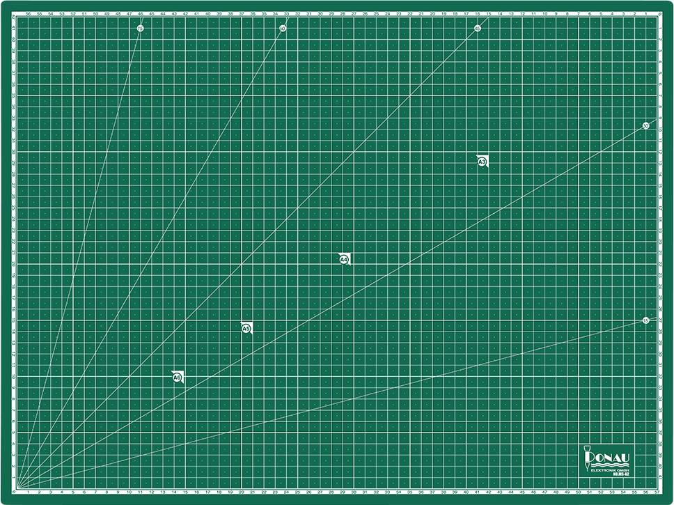 Une planche à découper verte avec des grilles blanches et des lignes d'angle. Un logo d'entreprise se trouve dans le coin inférieur droit.