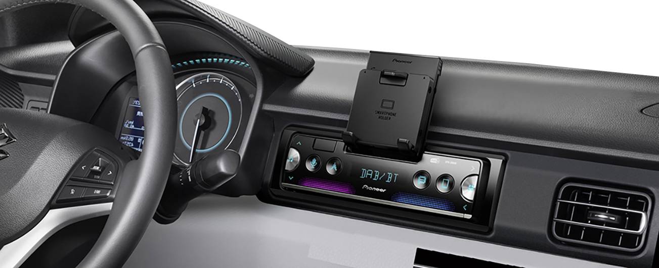 Affichage autoradio dans une voiture avec des éléments de commande éclairés et un affichage numérique indiquant 'FM 87.9'. Le volant est visible à gauche.