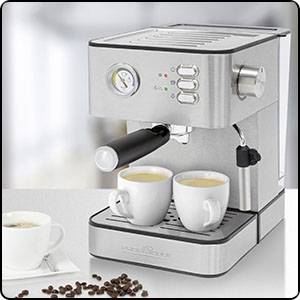 Machine à espresso en argent avec deux tasses à café blanches sur une table. À côté, des grains de café et une autre tasse vide sont disposés.