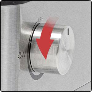 Bouton en acier inoxydable d'une cuisinière, tournant dans la direction d'une flèche, indiquant les positions d'interrupteur 'OFF' et une texture sur la surface.