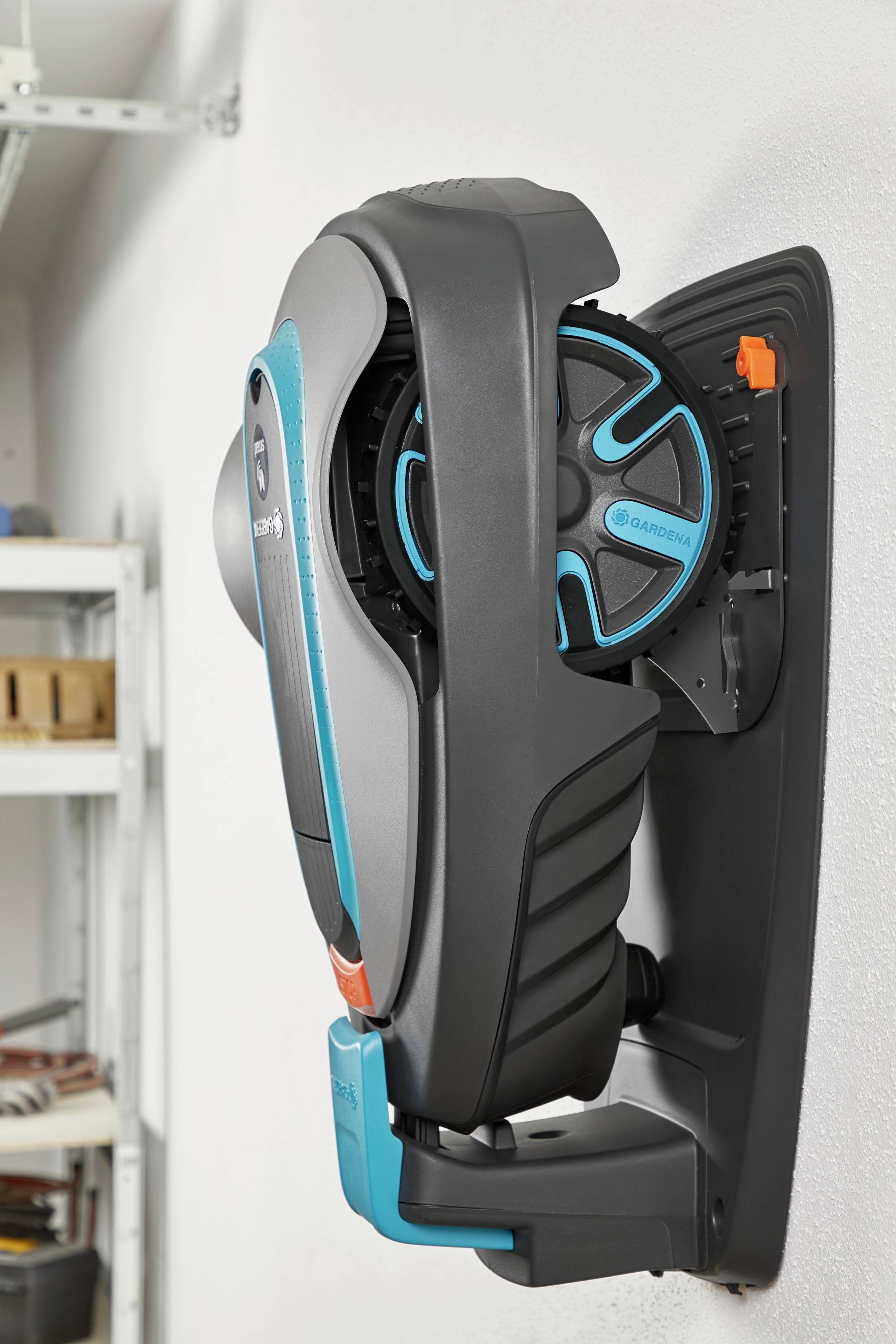 Support mural avec un outil de jardin moderne, ergonomique en noir et turquoise, monté dans un local de rangement.
