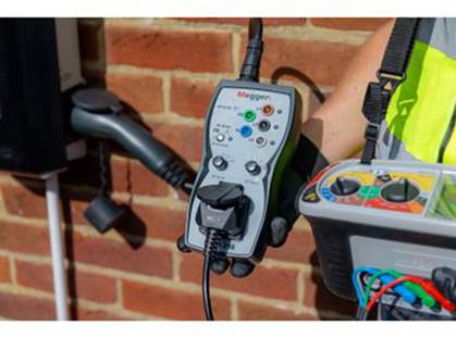 Un technicien utilise un appareil de test pour installations électriques, branché à une prise de courant, afin d'effectuer des tests.