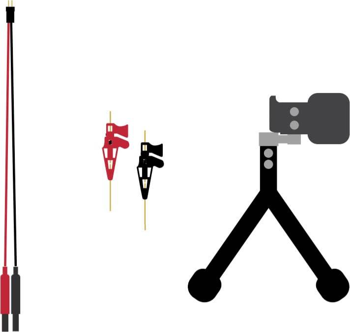Câble noir et rouge à gauche, deux pinces de câble (une rouge, une noire) au milieu, caméra sur trépied à droite. Équipement électronique.