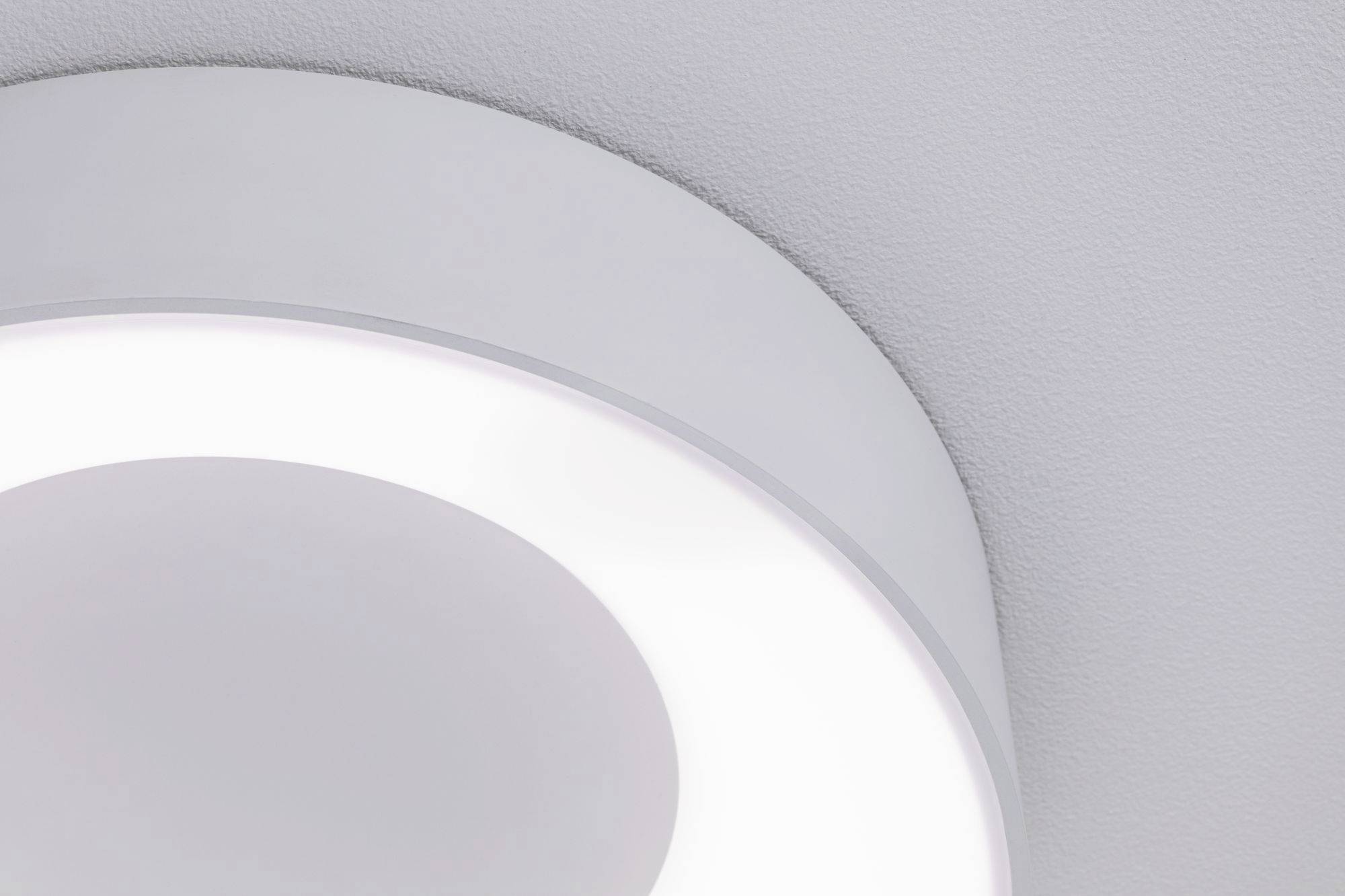 Un luminaire circulaire blanc avec une lumière douce fixé à un plafond gris.