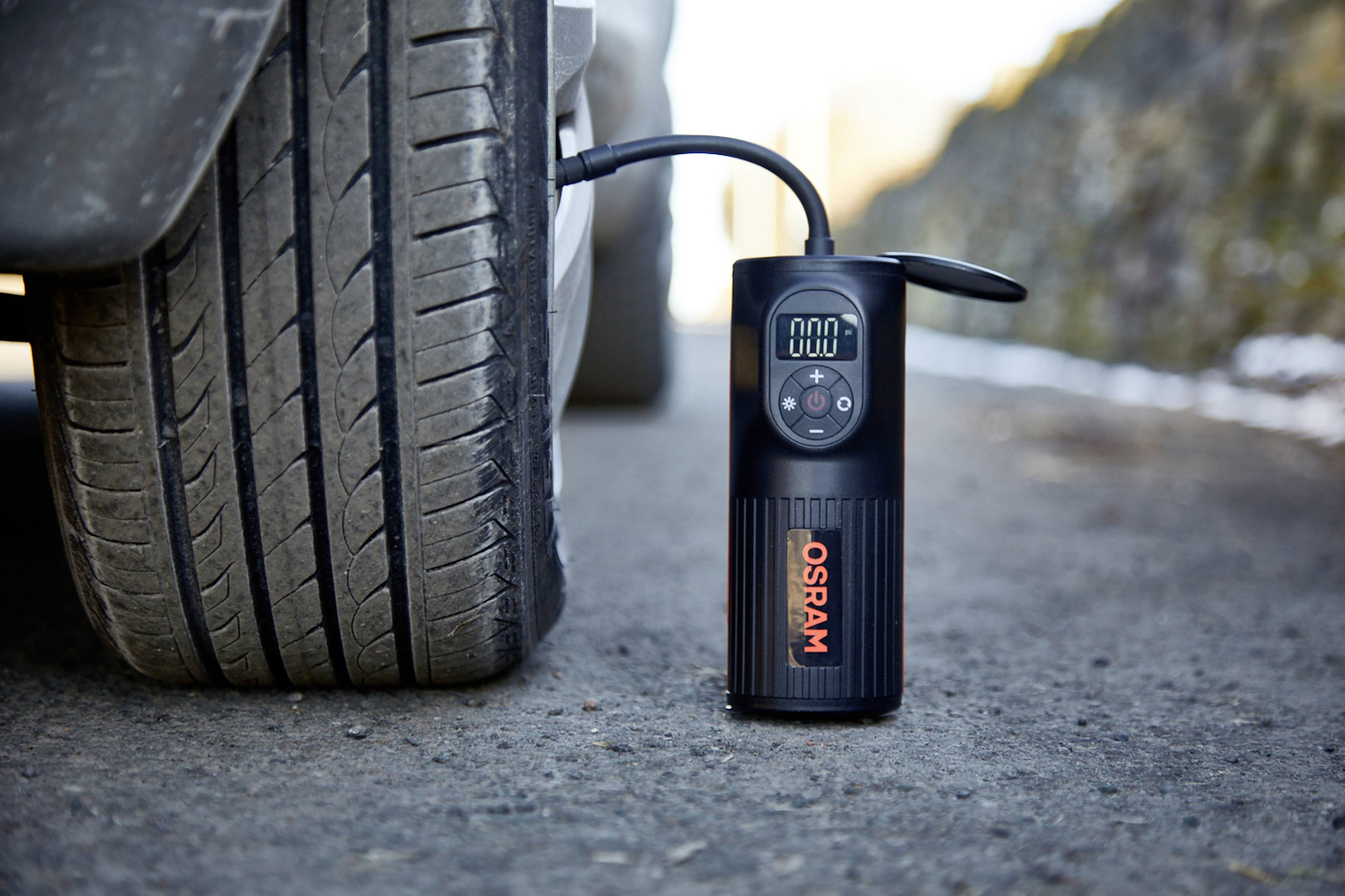 Un compresseur portable gonfle un pneu de voiture au bord de la route.