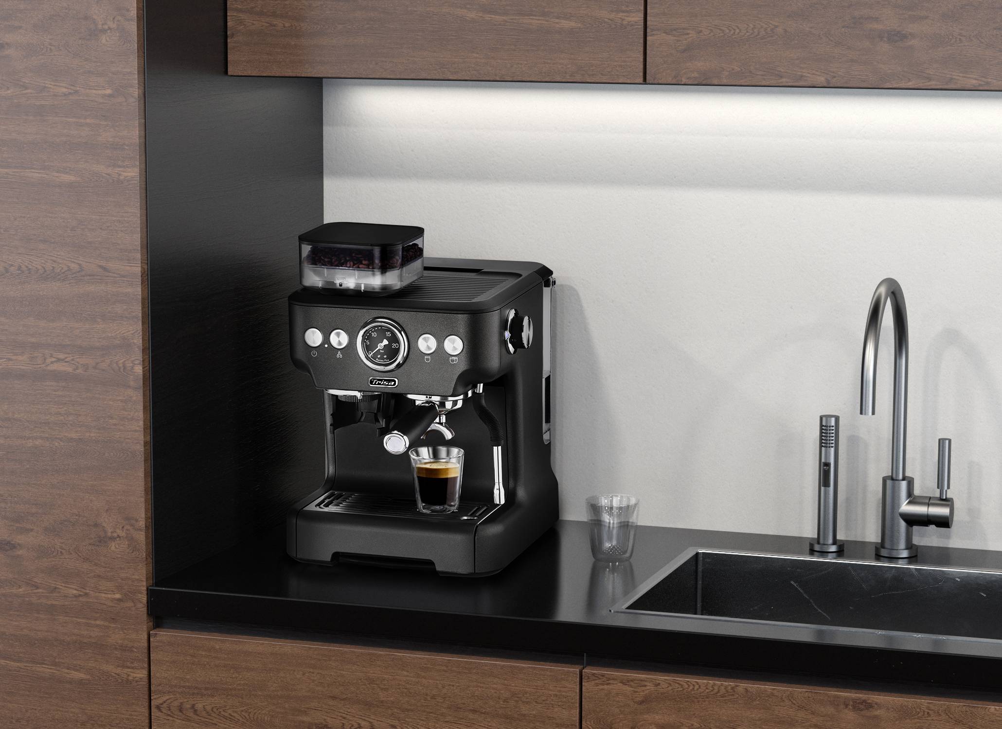 Machine à espresso sur le plan de travail de la cuisine à côté de l'évier, préparant un espresso frais dans un verre. Aménagement moderne avec des armoires en bois.