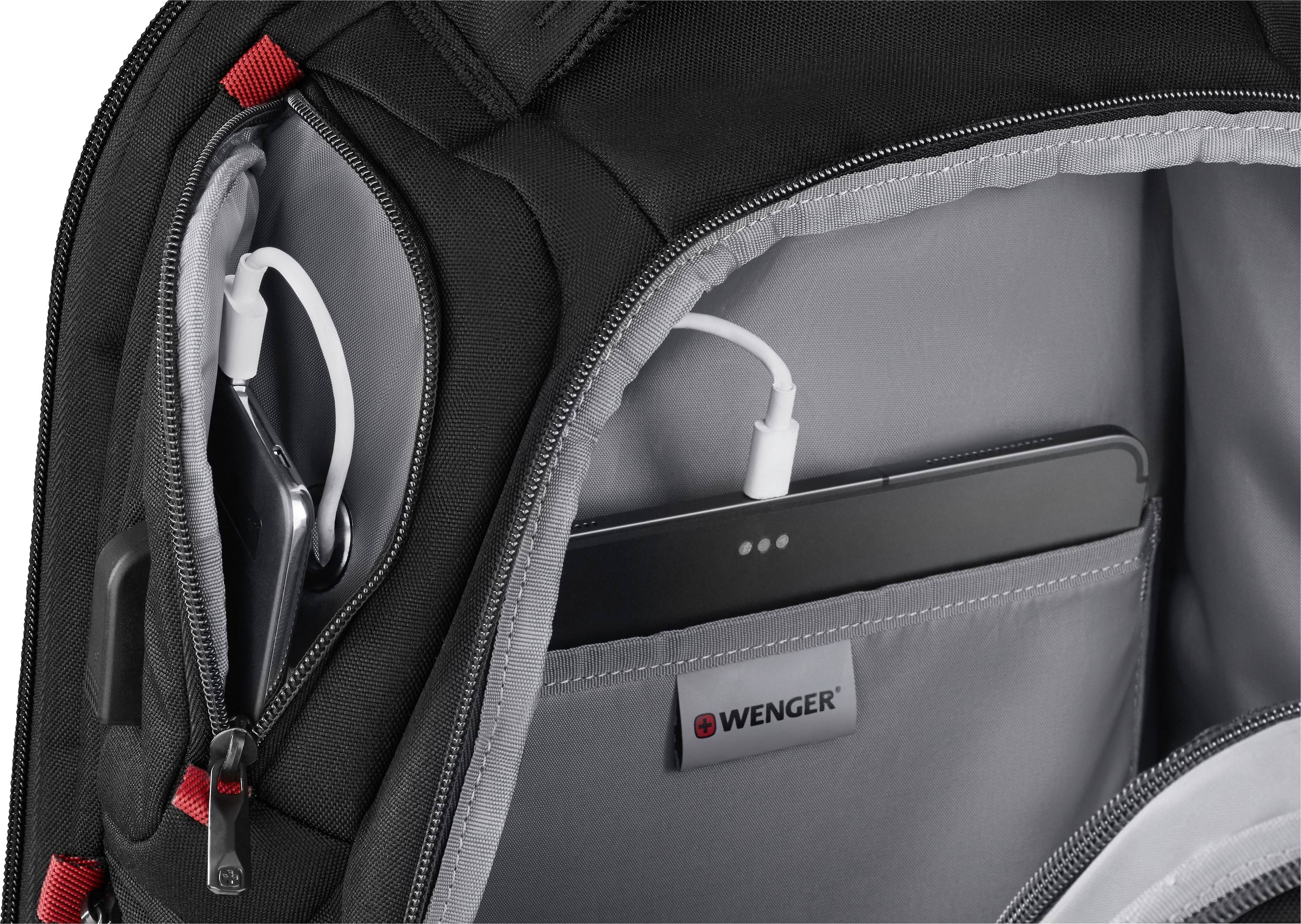 Sac à dos ouvert montrant plusieurs compartiments, dont un pour une tablette avec port USB. Nom de marque 'Wenger' sur la languette intérieure.