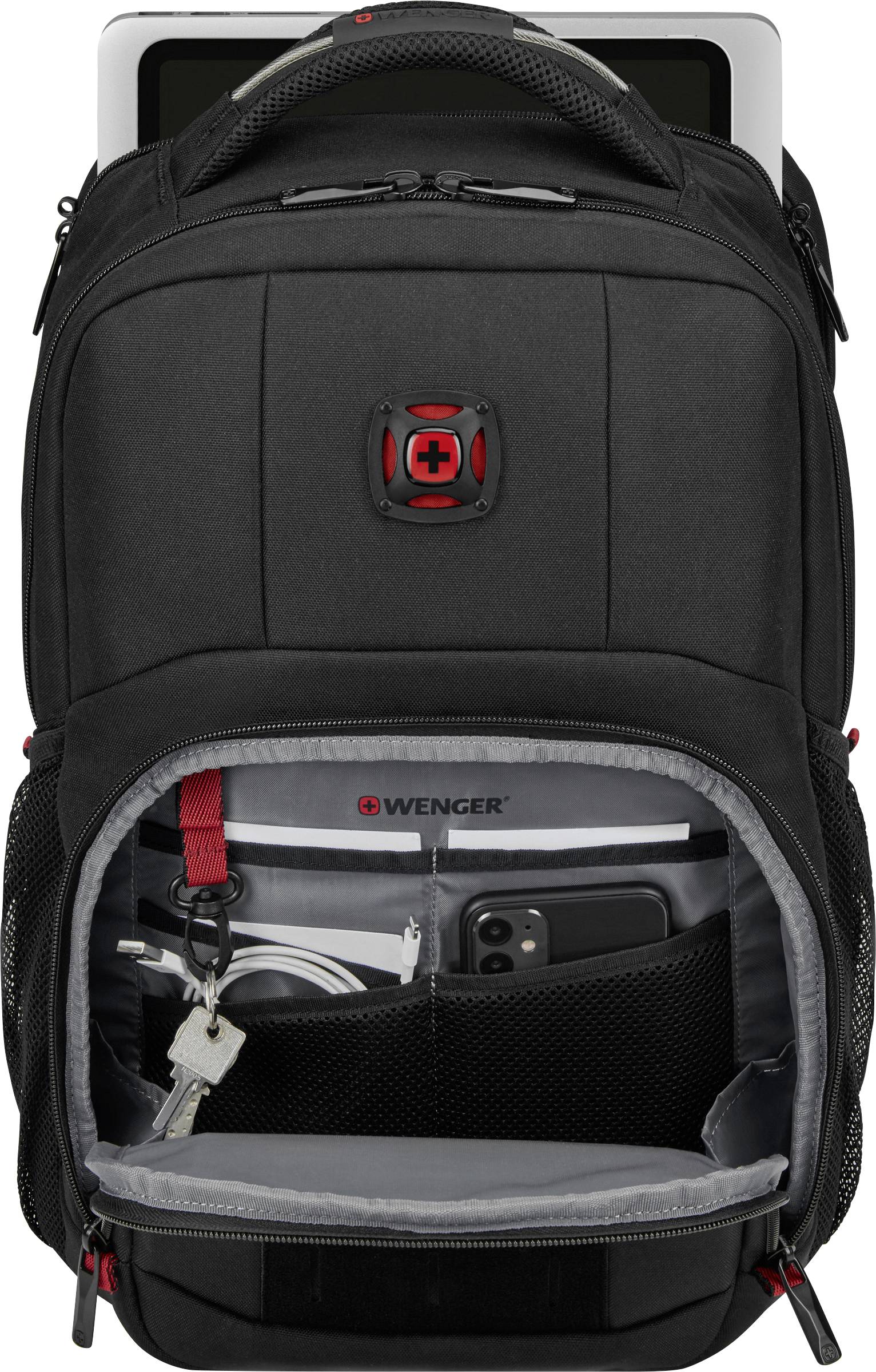 Sac à dos noir avec compartiment ouvert montrant une tablette, des clés, des stylos et un smartphone. Un ordinateur portable partiellement visible dans le compartiment arrière.