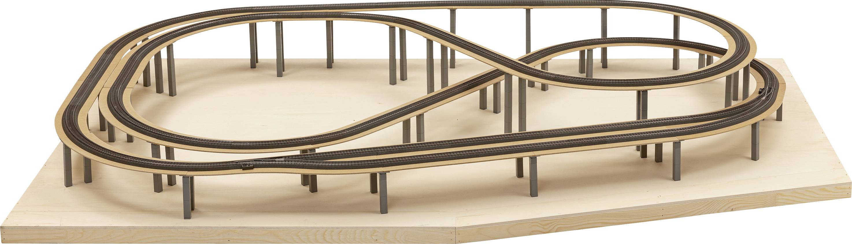 Un modèle miniature d'un circuit automobile en forme de huit sur une planche de bois. Le circuit comporte plusieurs niveaux et supports.