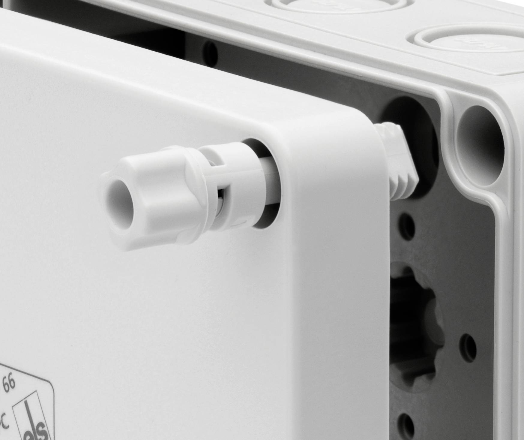 Gros plan sur un boîtier en plastique blanc avec un presse-étoupe sur le côté. Adapté aux applications électrotechniques.