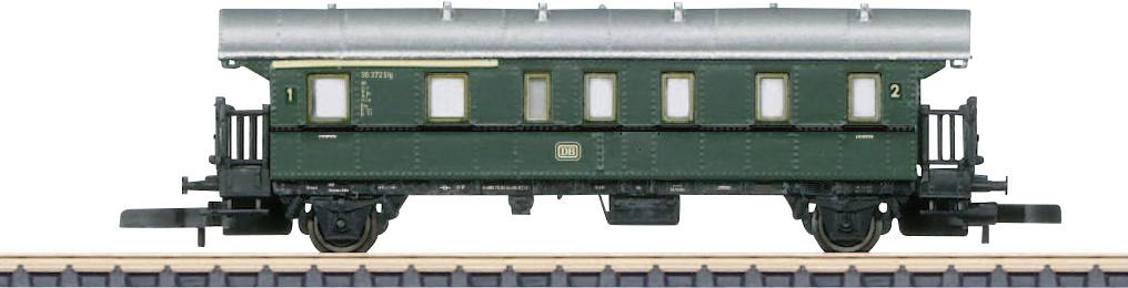Voiture ferroviaire verte ancienne pour passagers, vue latérale, avec plusieurs fenêtres et détails historiques.