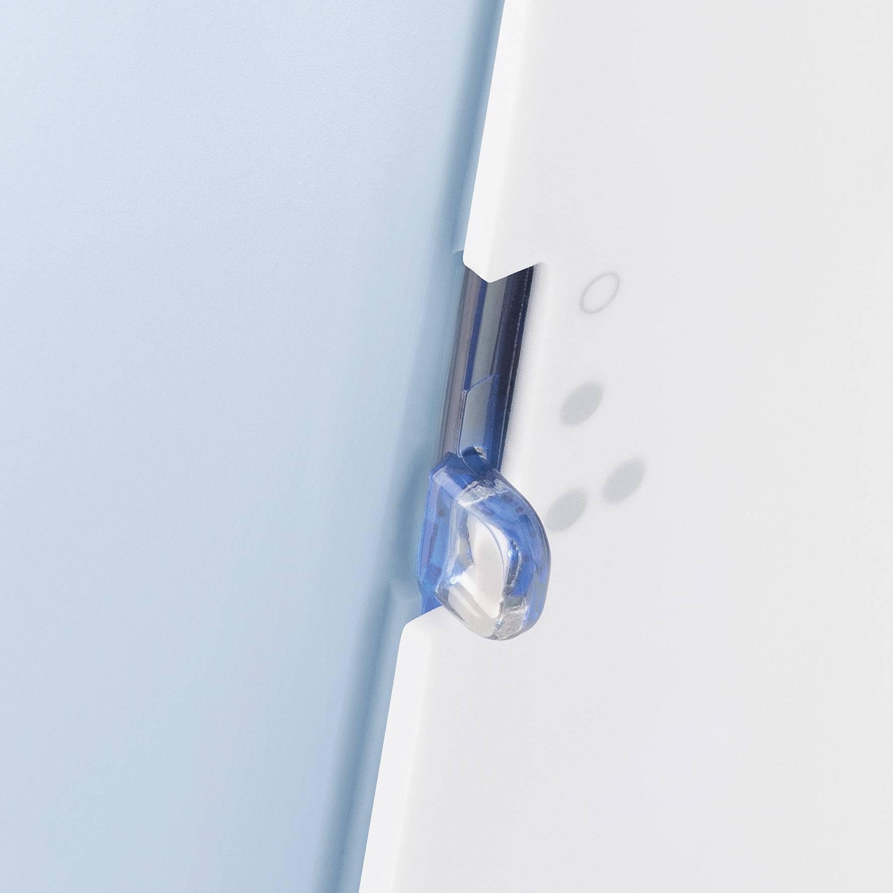 Un gros plan d'un objet bleu et blanc avec un clip transparent en plastique sur le côté.