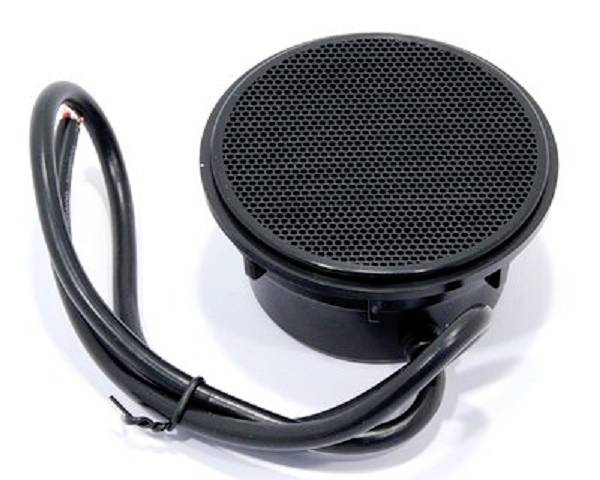 Un haut-parleur rond noir, relié par un câble, est posé sur une surface blanche.