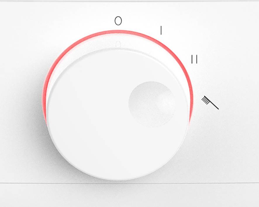 Un bouton rotatif blanc avec des accents rouges indique les positions '0', 'I', 'II' et un symbole de pinceau, probablement pour le contrôle d'un appareil.