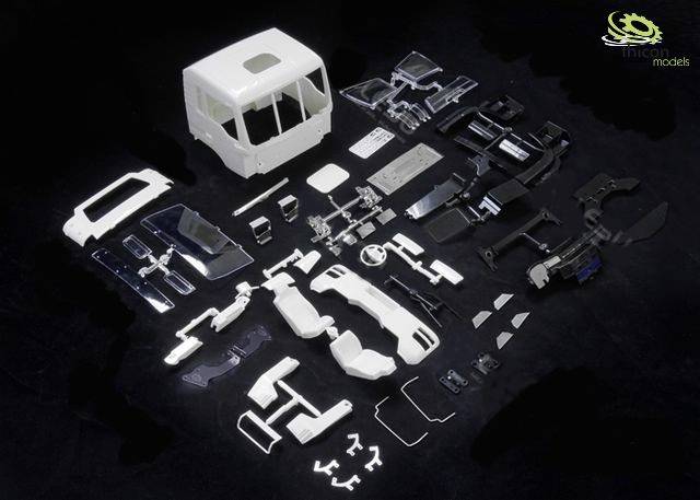 Une maquette comprenant de nombreuses pièces en plastique blanc et noir représentant une cabine de camion et ses accessoires.