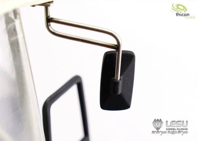 Gros plan d'un rétroviseur extérieur noir sur un modèle de véhicule, fixé par deux bras métalliques en forme de L. Un logo est visible en haut à droite.