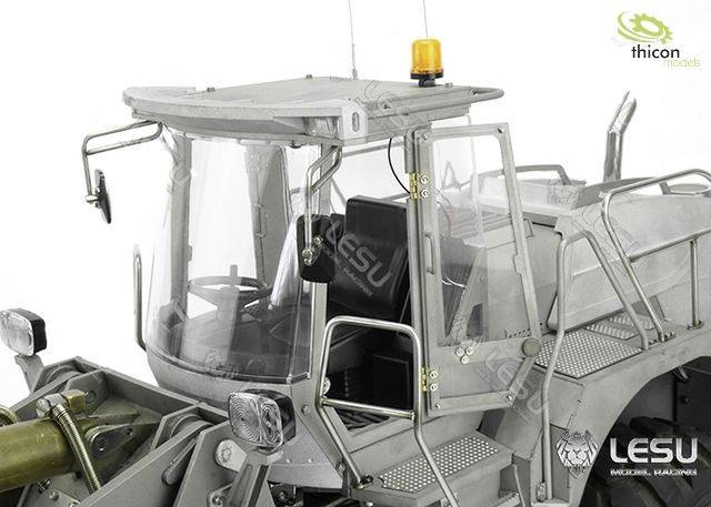 Un tracteur modèle gris avec des détails tels que cabine, échelle et châssis métallique, deux phares à l'avant et un feu orange de signalisation sur le dessus.