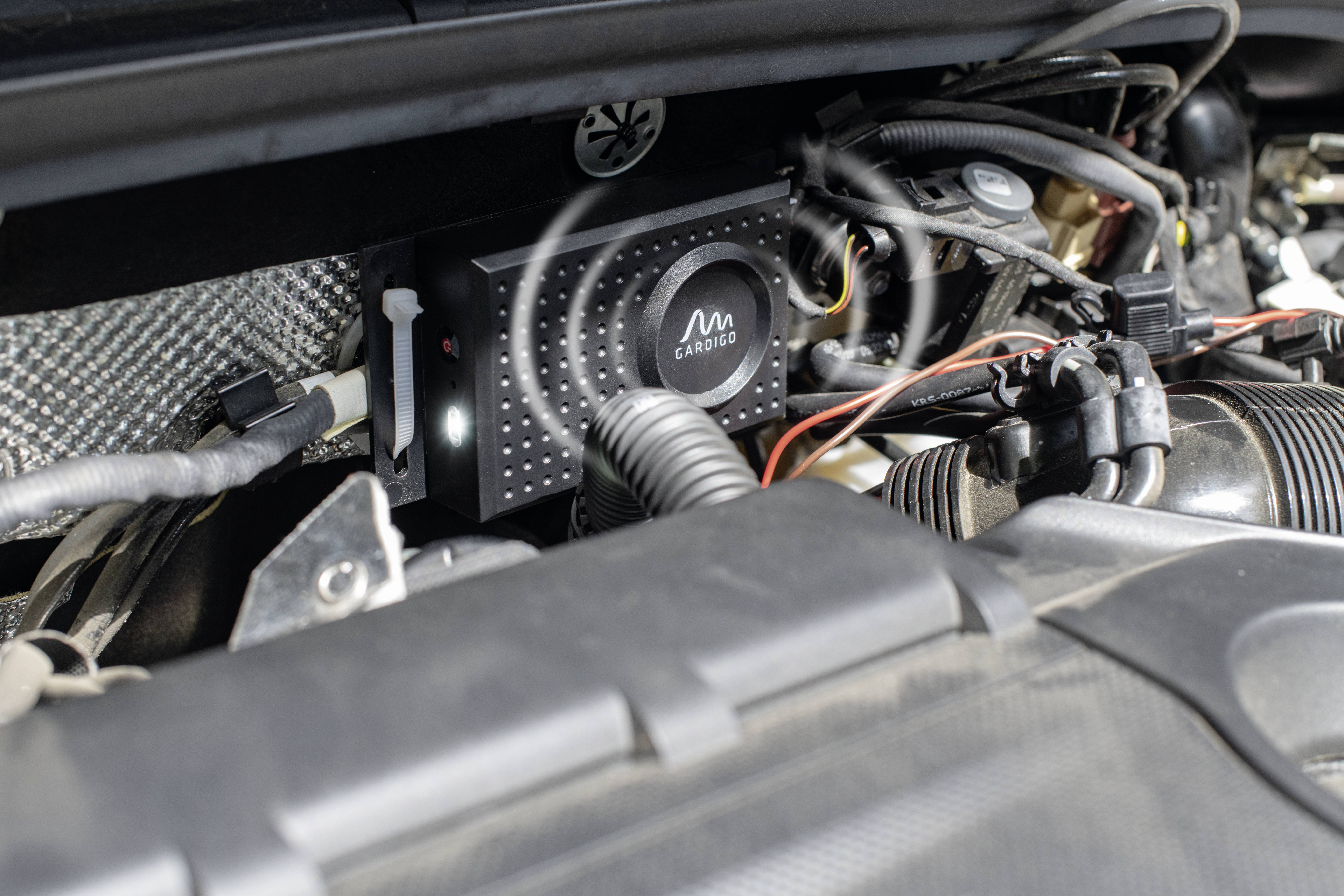 Un dispositif électronique dans le compartiment moteur d'un véhicule, plusieurs câbles y sont connectés.