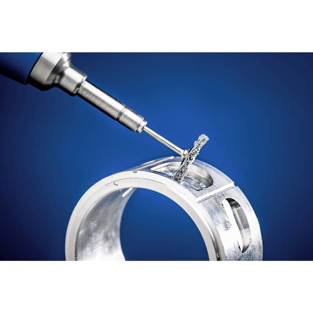 'Un foret industriel usiné une pièce métallique, des copeaux tombent. Gros plan sur un fond bleu. Illustre la précision et le processus d'usinage.'