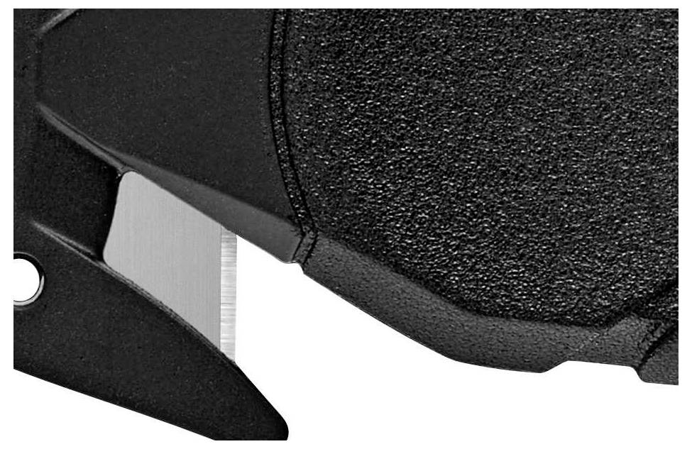 Gros plan d'un objet noir structuré avec un bord métallique saillant, probablement un outil ou un couteau.