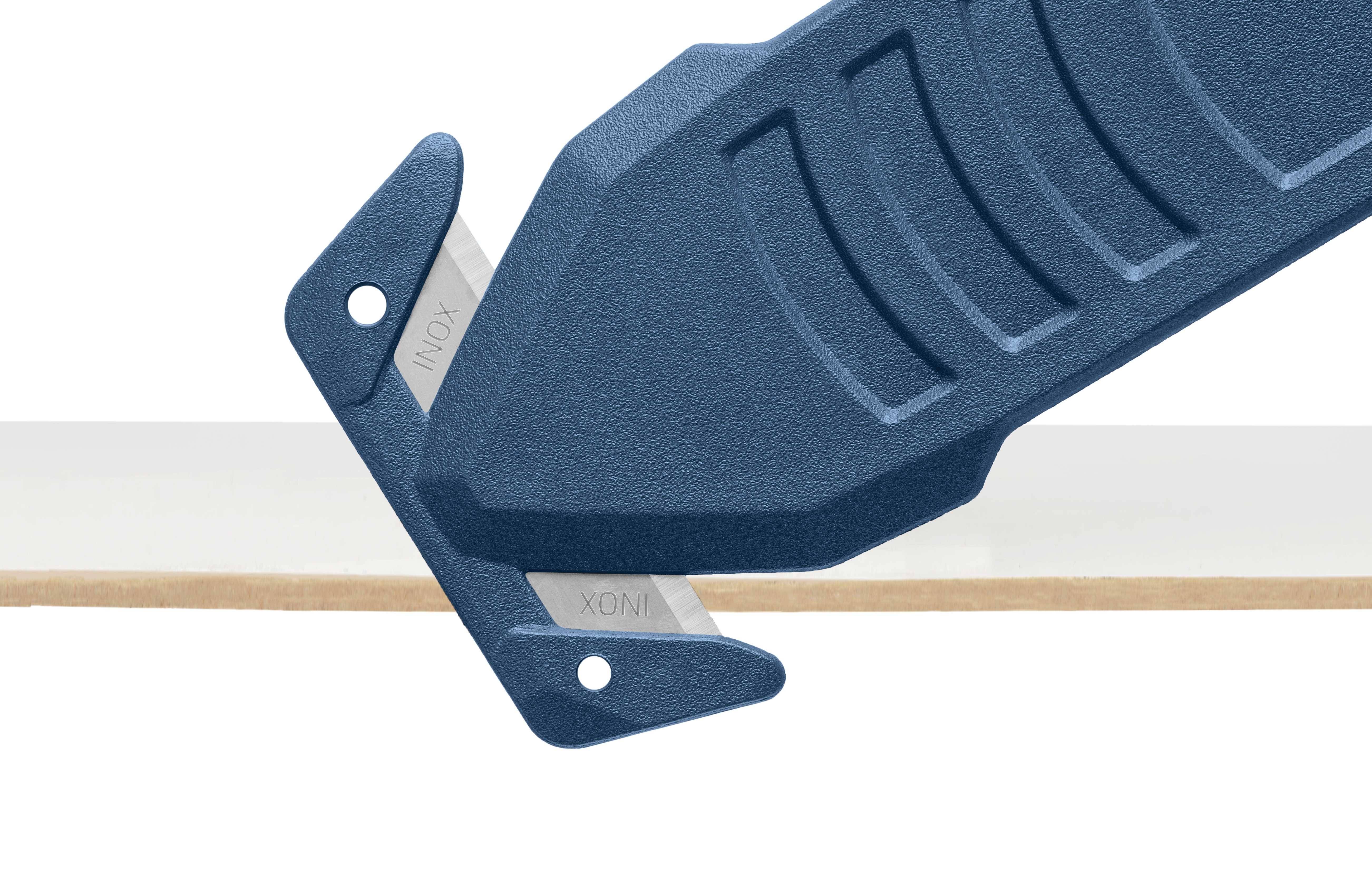 Un cutter de sécurité bleu coupe à travers une bande de carton. Le cutter possède une poignée ergonomique et une lame intégrée.