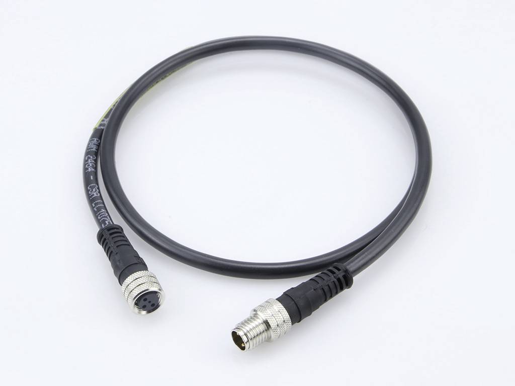 Câble noir avec deux fiches à ses extrémités, adapté pour les connexions électroniques, sur un fond blanc.