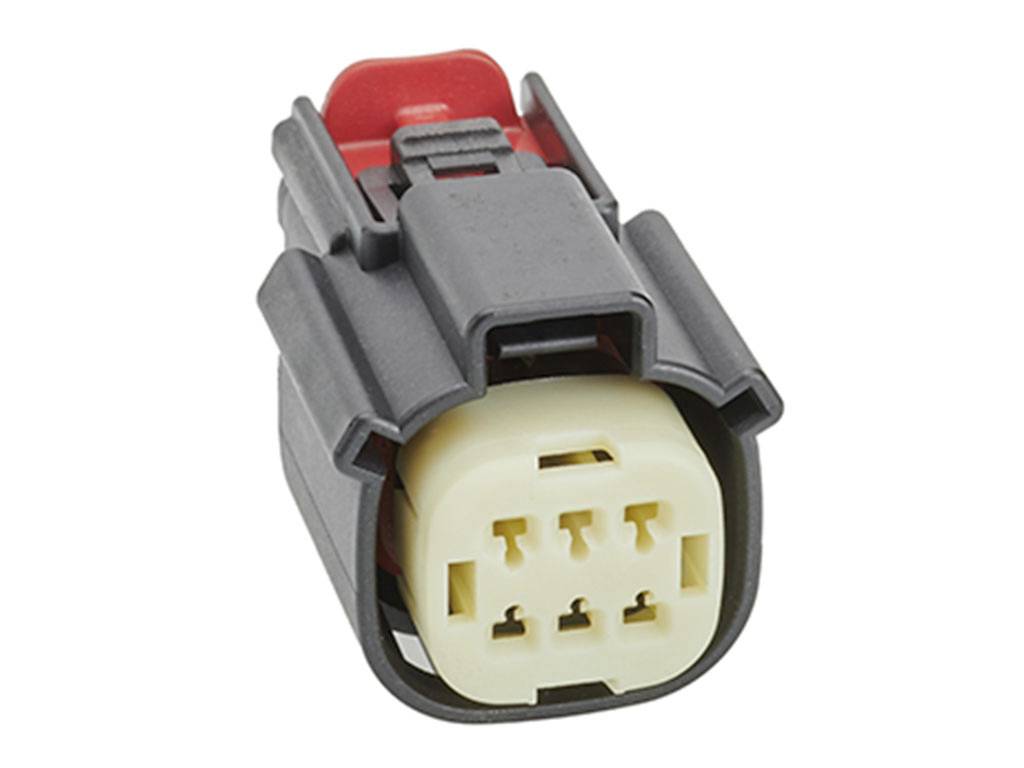 Un connecteur électrique gris et rouge à six emplacements.