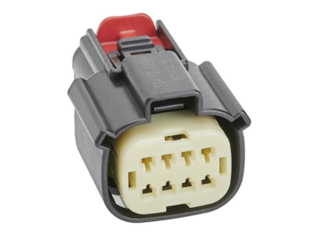 Une prise électrique noire rectangulaire avec six broches jaunes pour les connexions de câbles.