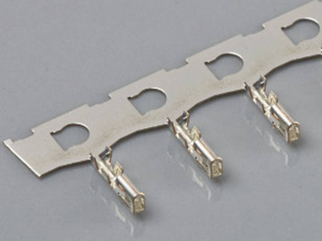 Une rangée de connecteurs métalliques fixés sur un support plat, sur un fond gris.