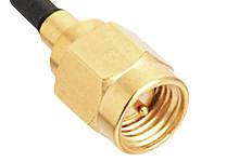 Gros plan sur un connecteur coaxial doré avec un câble noir, utilisé pour les connexions de signaux haute fréquence.