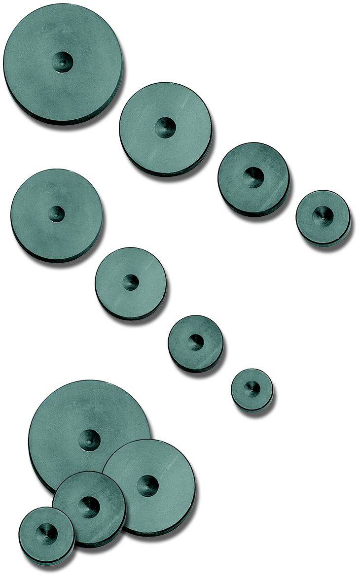 Plusieurs disques verts de différentes tailles sont répartis de manière asymétrique et projettent des ombres sur un fond blanc.