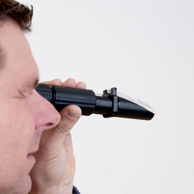 Un homme tient un otoscope et regarde à travers l'objectif, comme s'il effectuait un examen.