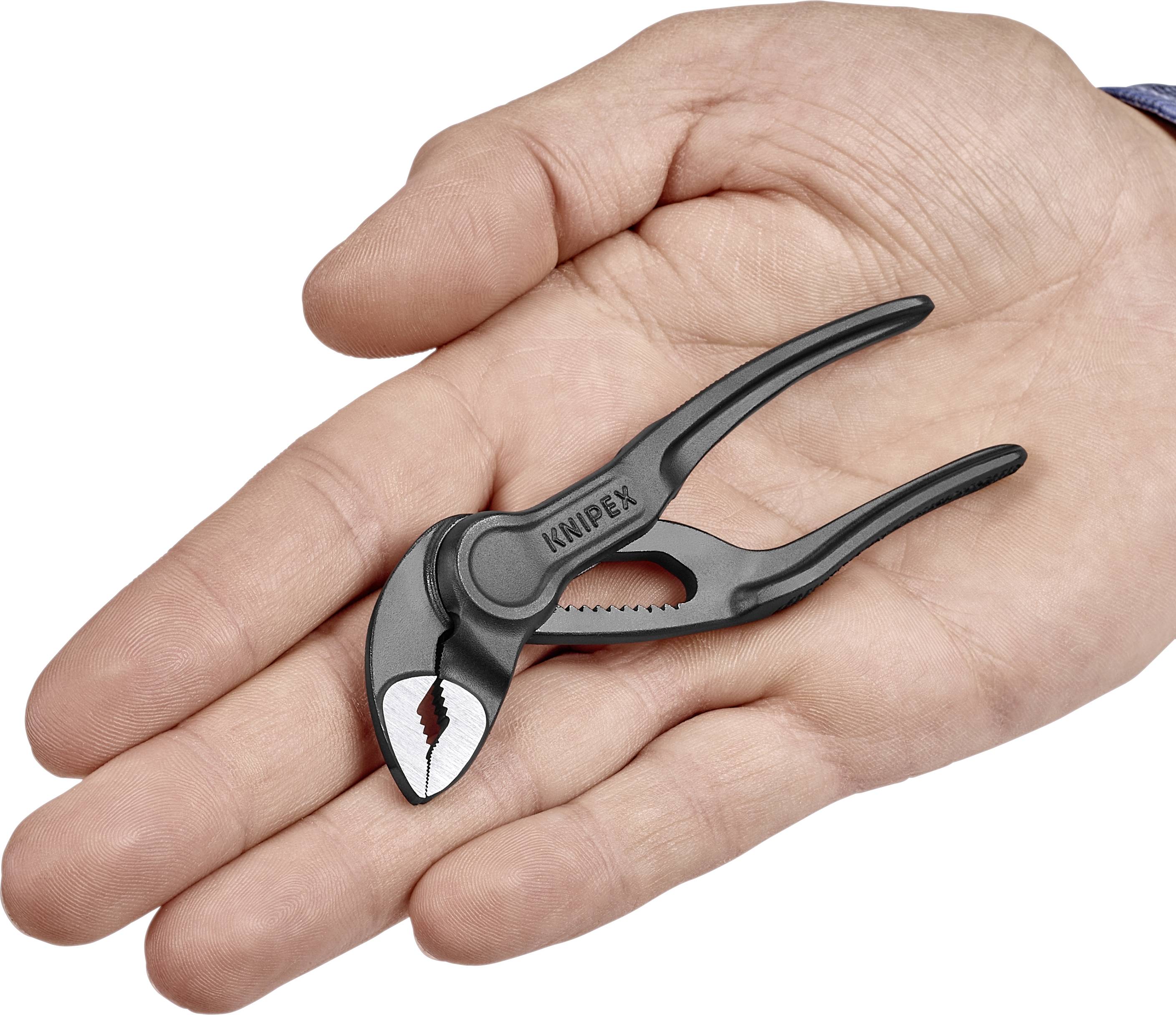 Une main tient une petite pince à bec droit noire portant l'inscription 'KNIPEX' sur la pince.