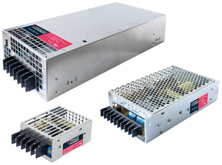 Trois transformateurs métalliques de différentes tailles. Tous sont munis de grilles de protection et de bornes de connexion noires.