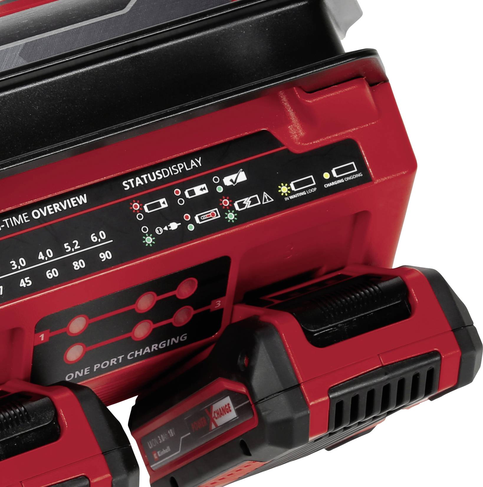 Un chargeur rouge avec deux batteries, affichant différents indicateurs de statut. Les symboles indiquant l'état de charge et le statut de fonctionnement sont codés par couleur.